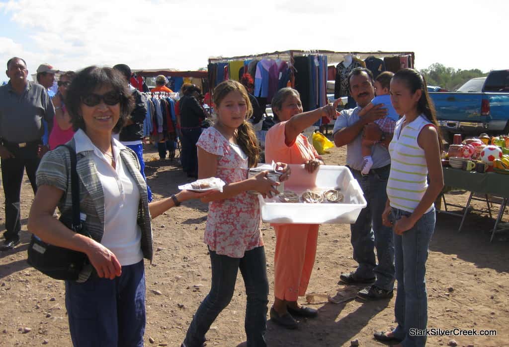 My mom posing with her butterscotch tart from the lady who selling them behind her.