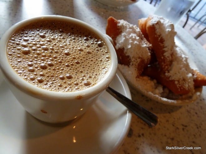 Café au Lait with Beignets Cup of café au lait next to a plate of fresh beignets
