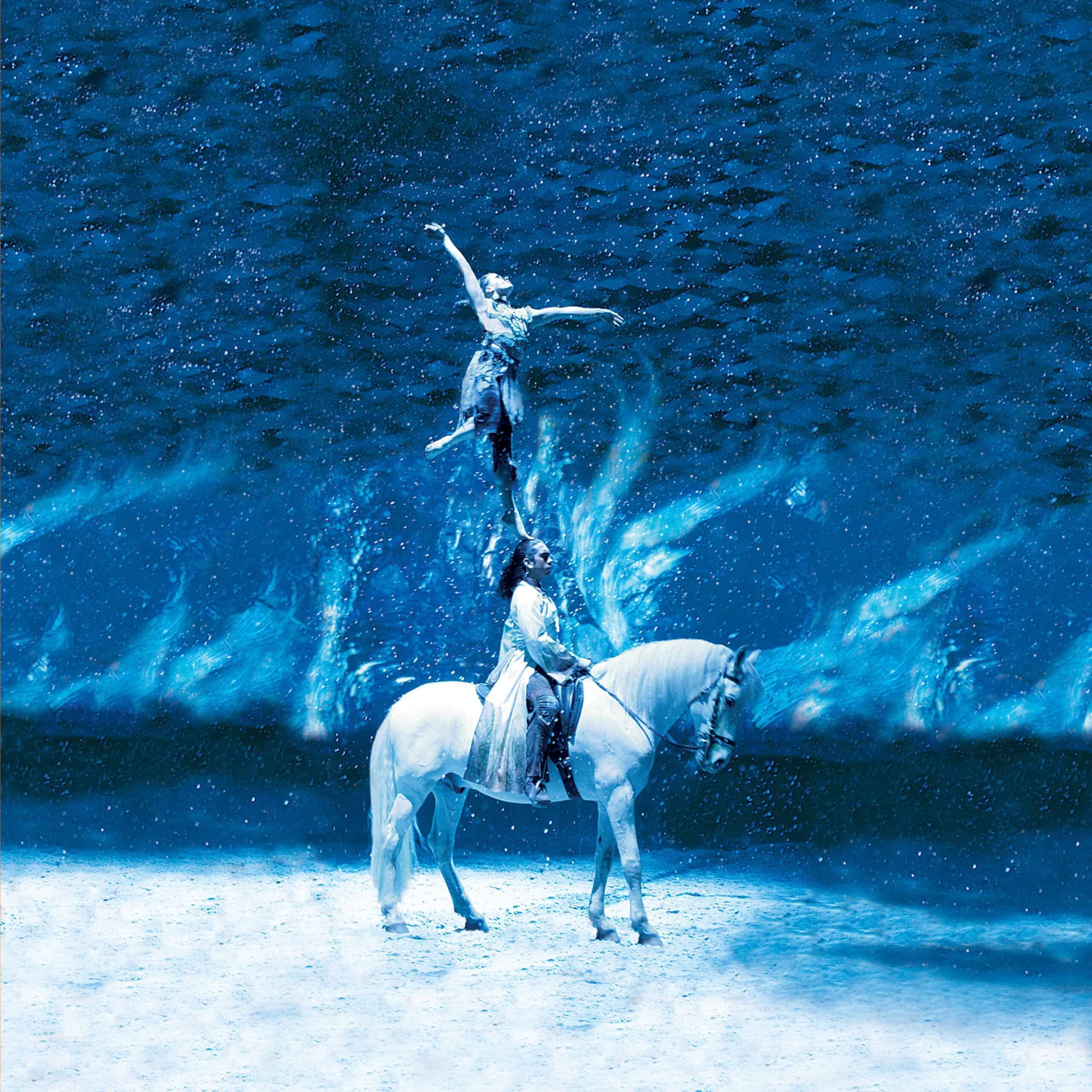 A rider and an aerialist in the return of CAVALIA under the White Big Top by AT&T Park in San Francisco. Photo Credit: Frédéric Chéhu