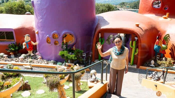 Florence Fang, owner, stands outside her dinosaur-filled Flintstone House in Hillsborough, CA