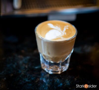 Cortado espresso served in a Gibraltar glass on a dark countertop, showcasing creamy microfoam and rich crema