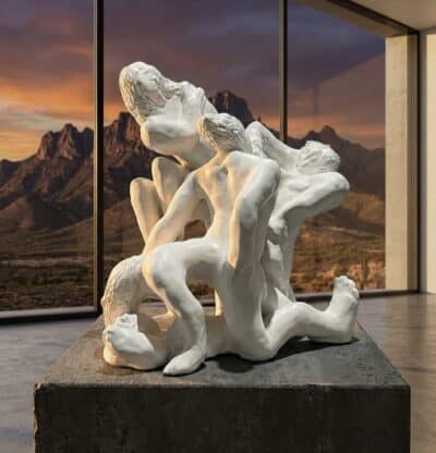 White sculptural tangle of human figures by Loni Stark in front of desert mountains at sunset, artwork for the Third Mind AI–human collaboration summit