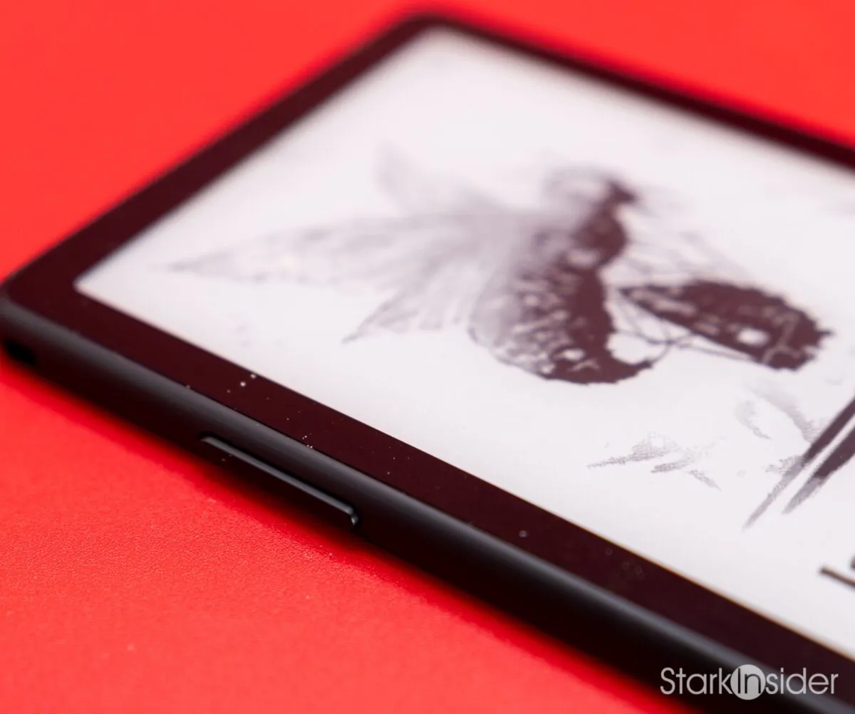Macro shot of the XTEINK X4 Pro's top corner and side button, its e-ink screen showing a moth illustration from the Lord of the Flies cover