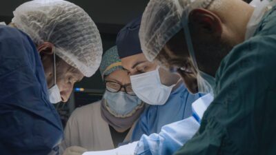 Surgeons in caps and masks operate together in a Gaza hospital in the documentary American Doctor