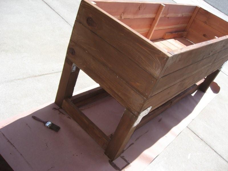 Applying a coat of stain a wooden DIY vegetable planter box - almost done!