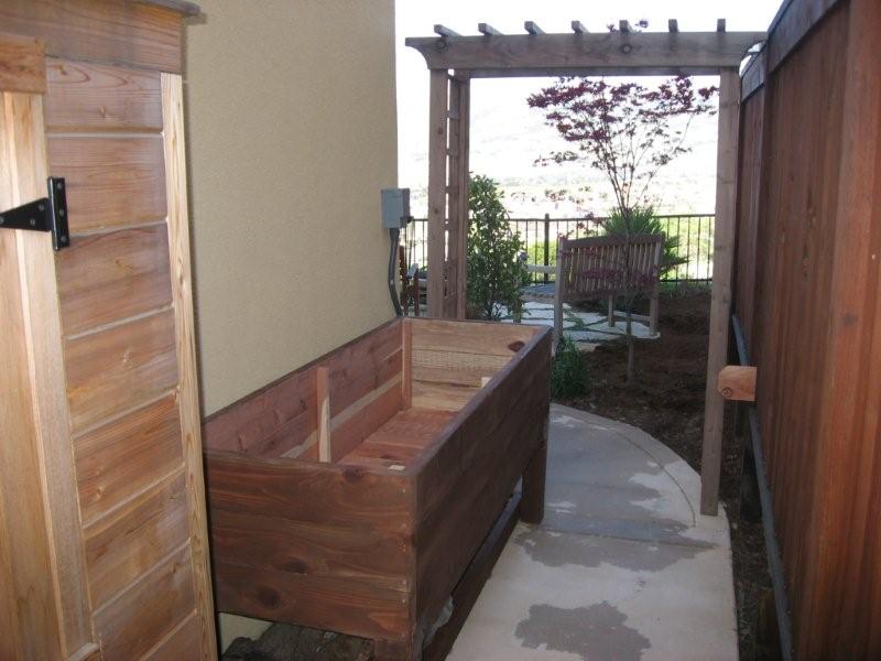 A completed DIY vegetable planter box at side of home